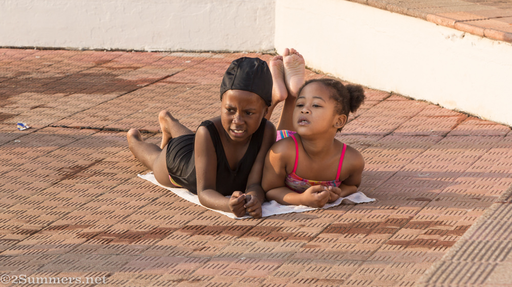 Little kids on towel at the pool