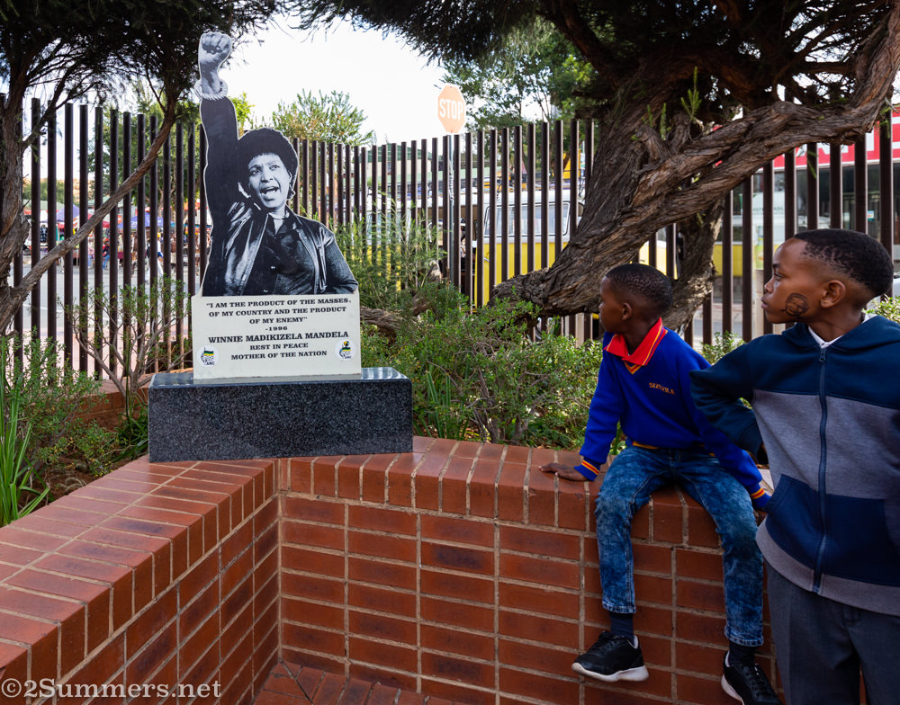 Kids in the Mandela House garden with a statue of Winnie Mandela