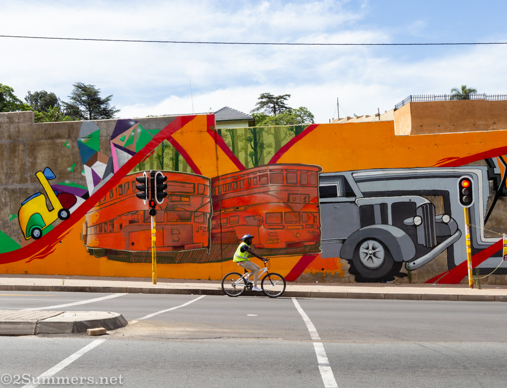 Cyclist passing the S-bend mural