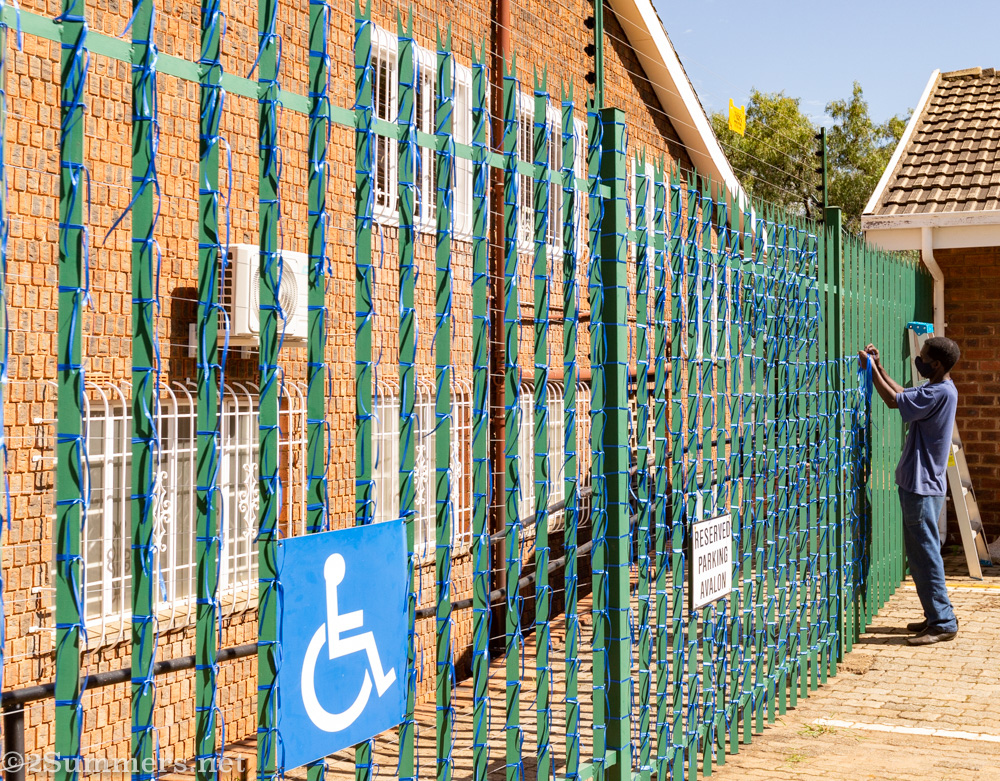 Leonard Makuya tying ribbons to the fence at St. James Church