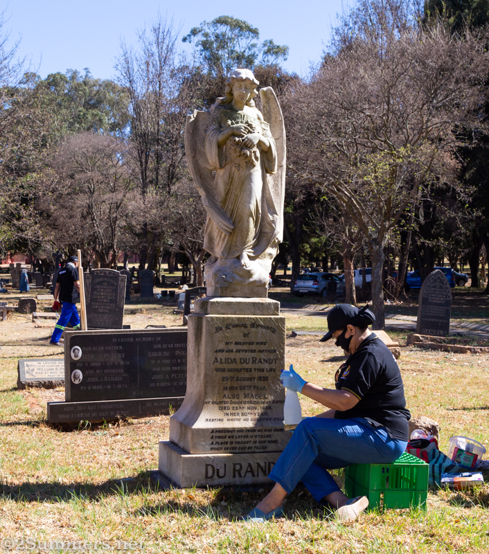 Volunteer cleaning headstone in Brixton Cemetery