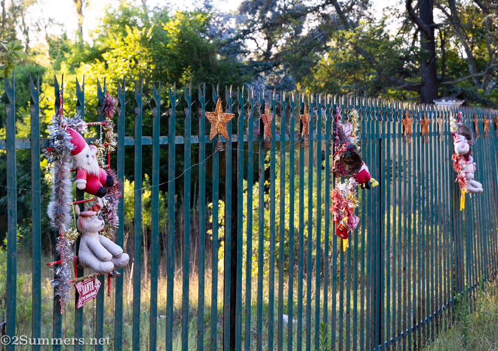 Christmas decorations on a palisade fence.