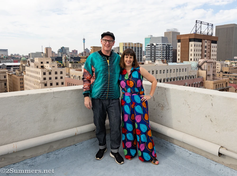Heather and Thorsten wearing our Caraci bomber jacket and jumpsuit on a rooftop in downtown Joburg.